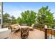Deck with cozy seating area, lush trees, and metal railing at 9928 Sylvestor Rd, Highlands Ranch, CO 80129