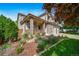 Charming two-story home with a cozy front porch and beautifully landscaped front yard filled with plants and flowers at 9928 Sylvestor Rd, Highlands Ranch, CO 80129