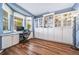 Bright home office featuring a large window, built-in storage cabinets, and stylish wood-look flooring at 9928 Sylvestor Rd, Highlands Ranch, CO 80129