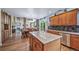 Open kitchen features a large island, wooden cabinets, stainless steel dishwasher, and seamless flow to dining area at 9928 Sylvestor Rd, Highlands Ranch, CO 80129