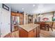 Spacious kitchen boasts wood cabinets, island with stone countertop, and stainless-steel refrigerator at 9928 Sylvestor Rd, Highlands Ranch, CO 80129