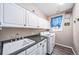The spacious laundry room features laminate flooring, white cabinets, and a front-loading washer and dryer at 9928 Sylvestor Rd, Highlands Ranch, CO 80129