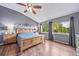 The primary bedroom offers ample natural light, hardwood flooring, and a ceiling fan at 9928 Sylvestor Rd, Highlands Ranch, CO 80129