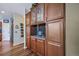 This wet bar features granite countertops, glass shelving, wood cabinets, and decorative backsplash at 9928 Sylvestor Rd, Highlands Ranch, CO 80129