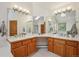 Bright bathroom featuring double sinks, wood cabinets, and ample counter space at 8 Mountain High Ct, Littleton, CO 80127