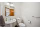 Cozy half bathroom featuring pedestal sink and a wood door at 8 Mountain High Ct, Littleton, CO 80127