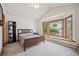 Cozy bedroom with a wooden-framed bed and large window at 8 Mountain High Ct, Littleton, CO 80127