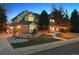 Inviting two-story home featuring lush landscaping, brick accents, and warm exterior lighting at dusk at 8 Mountain High Ct, Littleton, CO 80127