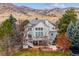 Back of house features deck, patio, nice landscaping, and mountain views at 8 Mountain High Ct, Littleton, CO 80127