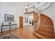 Grand foyer featuring a curved staircase, hardwood floors, and elegant lighting fixtures at 8 Mountain High Ct, Littleton, CO 80127