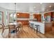 This kitchen features wood cabinets, granite countertops, a central island, and hardwood floors at 8 Mountain High Ct, Littleton, CO 80127