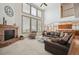 Bright living room featuring a fireplace, soaring ceilings, many windows and an adjacent kitchen at 8 Mountain High Ct, Littleton, CO 80127