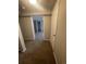 Carpeted hallway with neutral paint and ample closet space; this image has an open doorway at the end at 11644 Community Center Dr # 126, Northglenn, CO 80233