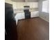Classic kitchen boasts white cabinets, modern black appliances, and hardwood flooring at 11644 Community Center Dr # 126, Northglenn, CO 80233