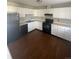 Clean kitchen featuring white cabinets, black appliances, and brown hardwood flooring at 11644 Community Center Dr # 126, Northglenn, CO 80233