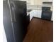 Traditional kitchen with black appliances, white cabinets and brown hardwood floors at 11644 Community Center Dr # 126, Northglenn, CO 80233