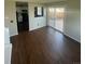 Hardwood flooring in living room showcasing sliding door access to outside, with view to kitchen at 11644 Community Center Dr # 126, Northglenn, CO 80233