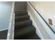 Carpeted stairway with white railing leads to the upper level of the home at 11644 Community Center Dr # 126, Northglenn, CO 80233