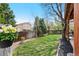 Spacious backyard with green lawn, trees, and a wooden fence, perfect for outdoor activities at 10512 Hyacinth St, Highlands Ranch, CO 80129