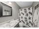 Bathroom features a shower with floral shower curtain, gray walls, and a large framed mirror at 10512 Hyacinth St, Highlands Ranch, CO 80129