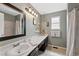 Bathroom features a long vanity with dark wood cabinets, large mirror, and stylish light fixture at 10512 Hyacinth St, Highlands Ranch, CO 80129