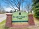 The Plum Valley Park sign, enhanced by a lush green backdrop, offers an inviting Highlands Ranch Metro District welcome at 10512 Hyacinth St, Highlands Ranch, CO 80129
