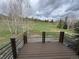 Inviting deck with wood-like finish, overlooking a serene green space with a fence and a cloudy sky above at 19 South Rd, Breckenridge, CO 80424