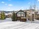 Back exterior view of a house in winter with snow covered ground and trees at 19 South Rd, Breckenridge, CO 80424
