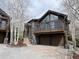Brown two-story home with stone accents, a balcony, and a two-car garage at 19 South Rd, Breckenridge, CO 80424