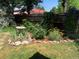 Landscaped backyard with stone pathways, mature trees, and a charming bird bath at 4401 S Lincoln St, Englewood, CO 80113