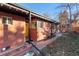 Mid-century brick home with a yellow door, landscaping, and a spacious backyard at 918 S University Blvd, Denver, CO 80209