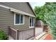 Inviting back deck featuring a retractable awning, brown railing, and mature evergreens at 13424 W 64Th Pl, Arvada, CO 80004