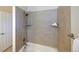 Shower-tub combo with tiled surround, handheld shower head and built-in shelves at 13424 W 64Th Pl, Arvada, CO 80004