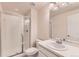 Bright bathroom featuring a glass-enclosed shower, white vanity with sink, and a large mirror for a clean and modern feel at 13424 W 64Th Pl, Arvada, CO 80004