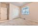 Cozy bedroom with a window and a closet featuring bi-fold doors, complemented by neutral-toned walls and carpet at 13424 W 64Th Pl, Arvada, CO 80004