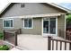 Back deck with brown railings, sliding glass door, and retractable awning above a window at 13424 W 64Th Pl, Arvada, CO 80004