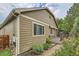 Exterior view of home's siding, garden area, and back deck at 13424 W 64Th Pl, Arvada, CO 80004