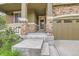 A welcoming front porch entrance with stone pillars and adjacent to a two car garage at 13424 W 64Th Pl, Arvada, CO 80004