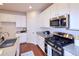 Well-equipped kitchen with granite countertops, stainless steel appliances, and wood flooring at 13424 W 64Th Pl, Arvada, CO 80004