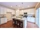 Bright kitchen with white cabinets, stainless steel appliances, and central island with barstool seating at 13424 W 64Th Pl, Arvada, CO 80004