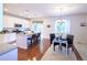 Open-concept kitchen and dining area with stainless steel appliances, an island, and hardwood floors at 13424 W 64Th Pl, Arvada, CO 80004
