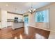 Open-concept kitchen and dining area with granite counters, stainless steel appliances and wood floors at 13424 W 64Th Pl, Arvada, CO 80004