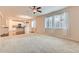 Bright living room featuring large windows with sheer curtains, neutral carpet, and open access to the kitchen area at 13424 W 64Th Pl, Arvada, CO 80004