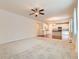 Open-concept living room with neutral carpet and a ceiling fan, seamlessly connected to a modern kitchen with stainless appliances at 13424 W 64Th Pl, Arvada, CO 80004