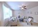 Bright living room with plush seating, ceiling fan, and natural light from large windows at 13424 W 64Th Pl, Arvada, CO 80004
