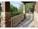 Covered front porch featuring stone pillars and a white wooden railing at 13424 W 64Th Pl, Arvada, CO 80004