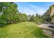 Expansive backyard with lush green grass, mature trees, and a concrete patio perfect for outdoor gatherings at 2276 S Dover Way, Lakewood, CO 80227