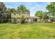 Large backyard featuring a well-maintained lawn, mature trees, and a patio area perfect for entertaining at 2276 S Dover Way, Lakewood, CO 80227