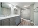 Bathroom featuring a double vanity with marble countertop and a glass-enclosed tiled shower at 2276 S Dover Way, Lakewood, CO 80227