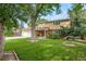 Charming two-story home boasts a lush green lawn and mature trees providing ample shade at 2276 S Dover Way, Lakewood, CO 80227